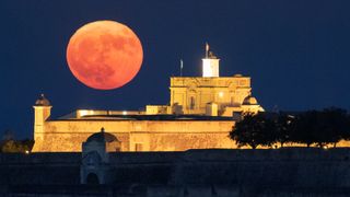 The first supermoon of 2023 rises above the Fort of Santa Luzia in Portugal on July 3.