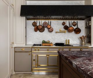 A traditional range cooker with hanging copper pots above