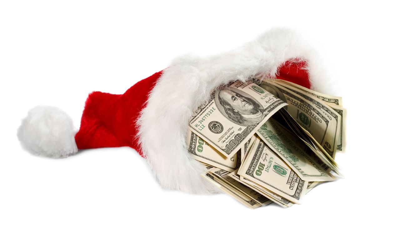 Santa&#039;s hat filled with hundred dollar bills on blank background