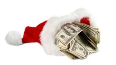 Santa's hat filled with hundred dollar bills on blank background