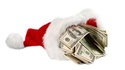 Santa's hat filled with hundred dollar bills on blank background