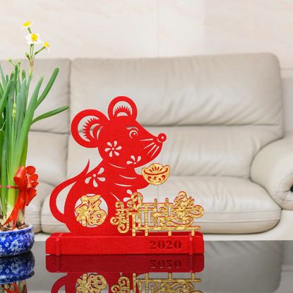 A pot of daffodils next to a Lunar New Year rat sculpture