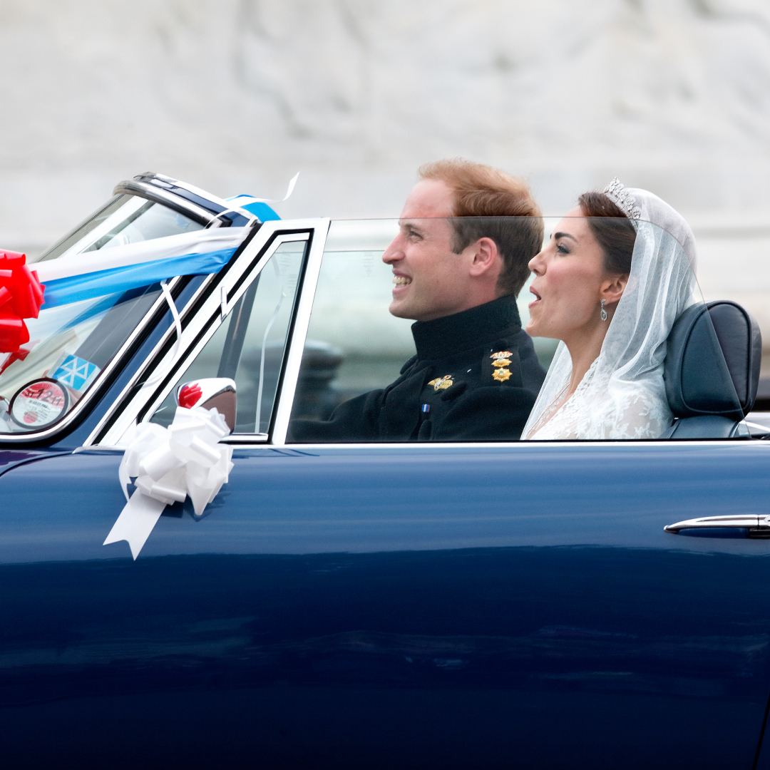 Prince William and Princess Kate riding in a convertible on their wedding day