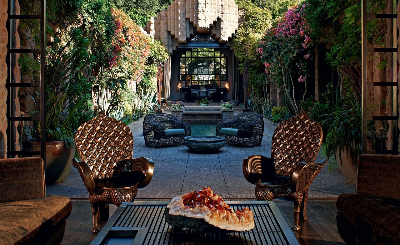 Outdoor courtyard with lots of plants &amp; ornate chairs