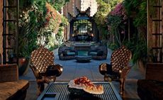 Outdoor courtyard with lots of plants & ornate chairs