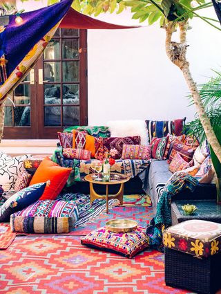 Colorful patio with lanterns, cushions, and chairs