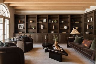 A family room with a moody palette, with built-in shelves and