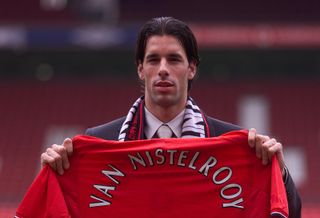 Ruud van Nistelrooy holds a Manchester United shirt at Old Trafford after signing for the Red Devils in April 2001.