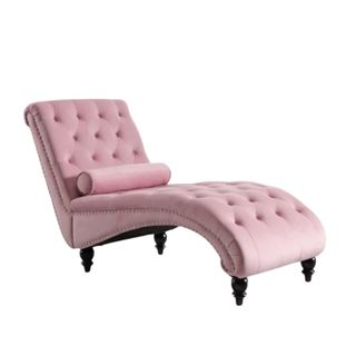 A baby pink chaise with a curved base, tufted button design, a cylinder throw pillow, and black plastic legs