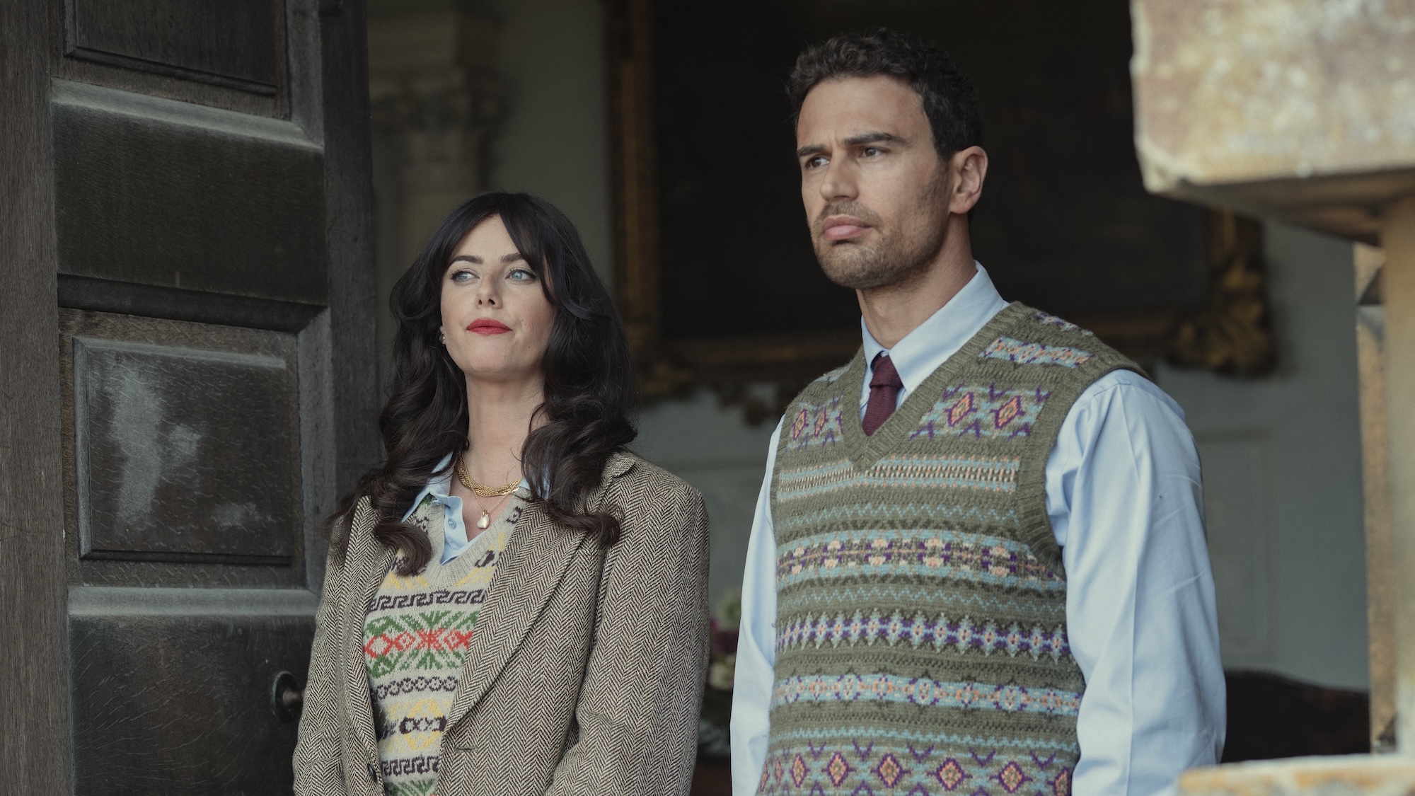 Eddie in dress shirt, tie and vest with Susie in vest and blazer standing at front door in The Gentlemen Season 2