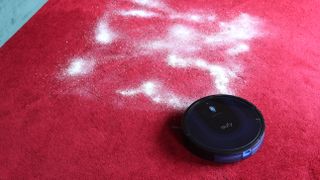 Eufy Robovac 15C Max on a red carpet covered in flour