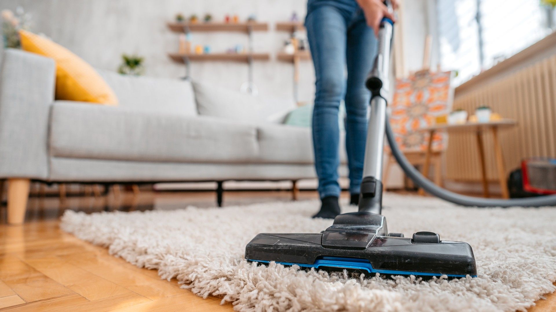 woman vacuuming rug in living room