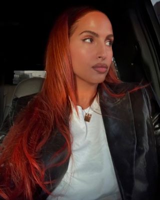A woman with long red hair looking off to the side.