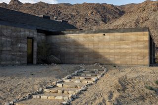 morning dove, a new house at twentynine palms by homestead modern, showing rammed earth walls, rough and contemporary volumes and windows out to desert landscape views