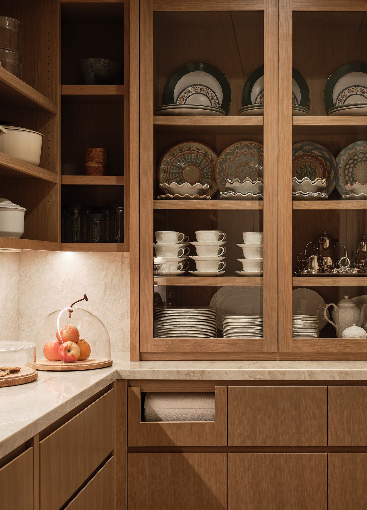 a pantry with glass fronted cabinets for storing plates