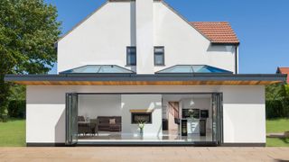 a house extension with modern roof lanterns and bifolding doors