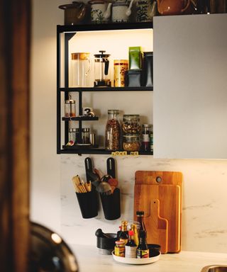 white kitchen with black modular style shelving, white wall cabinet, marble style backsplash,