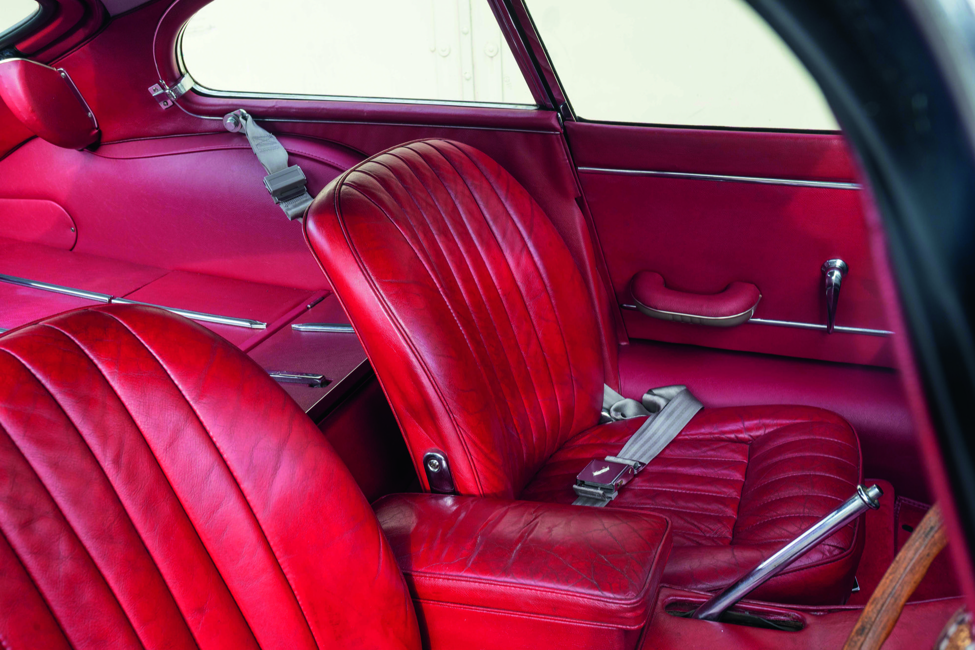 An interior shot of the red leather interior of a conserved jaguar E-Type