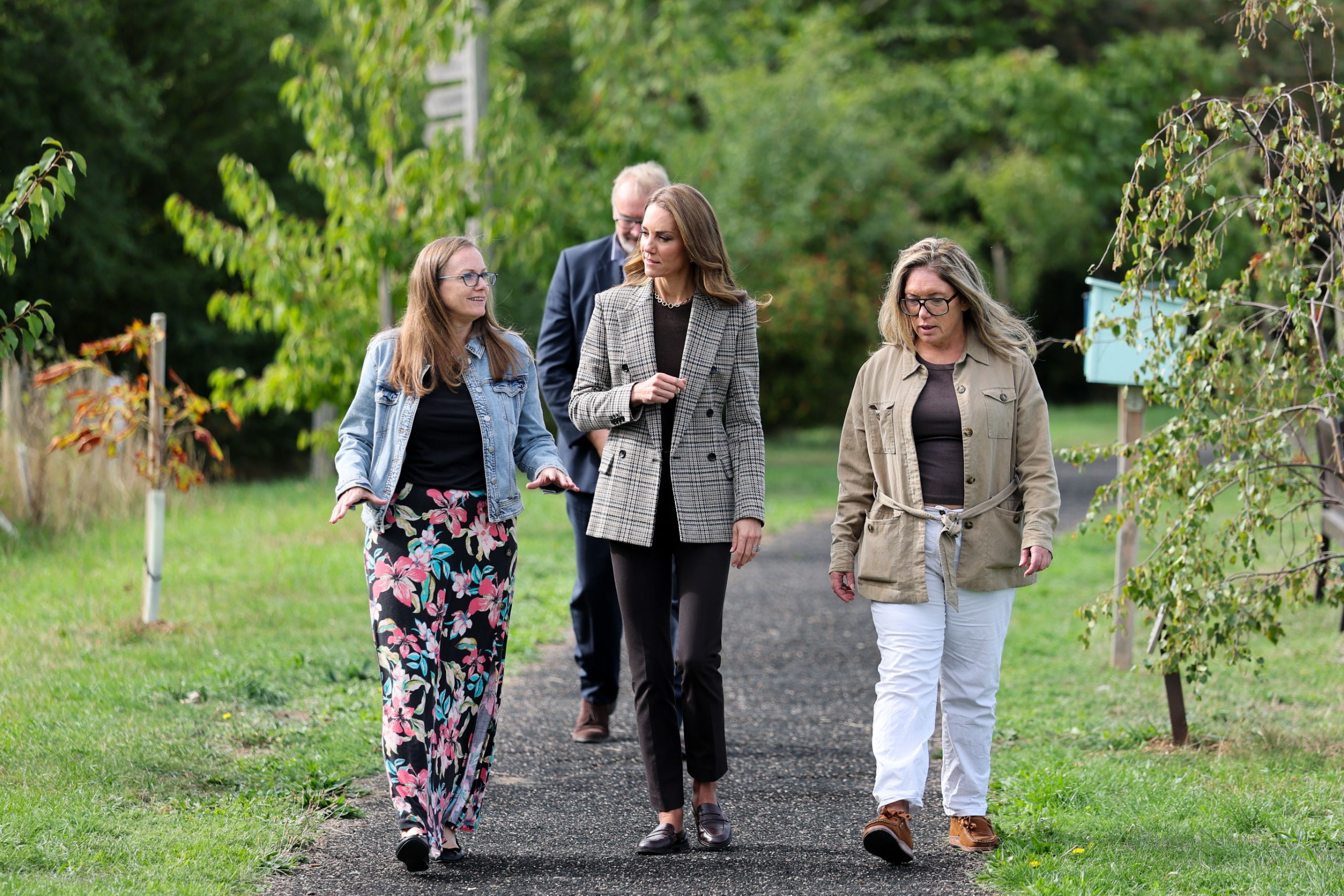 Princess Kate walking between two women in a park