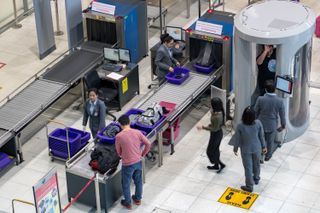 Travelers unpack bags at airport security