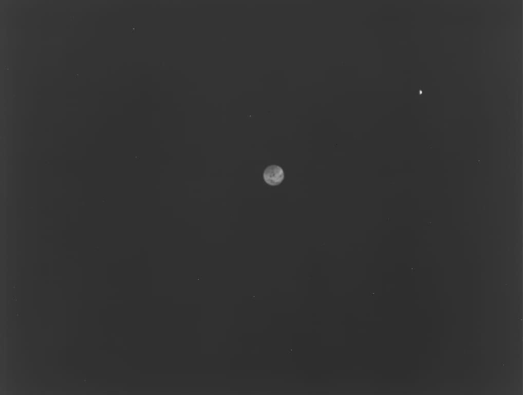 Black and white view of Earth and moon, slightly hazy.