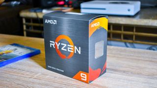 The retail packaging for the AMD Ryzen 9 5900X on a coffee table