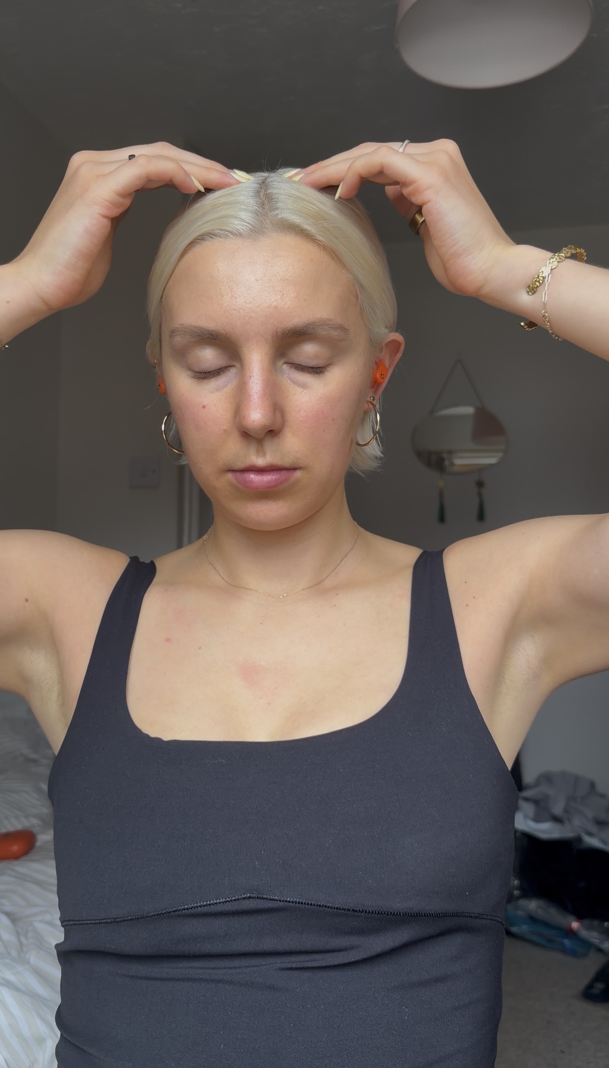 A woman practices EFT tapping with her eyes closed and hands on her head