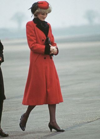 Princess Diana in a red coat with a black collar