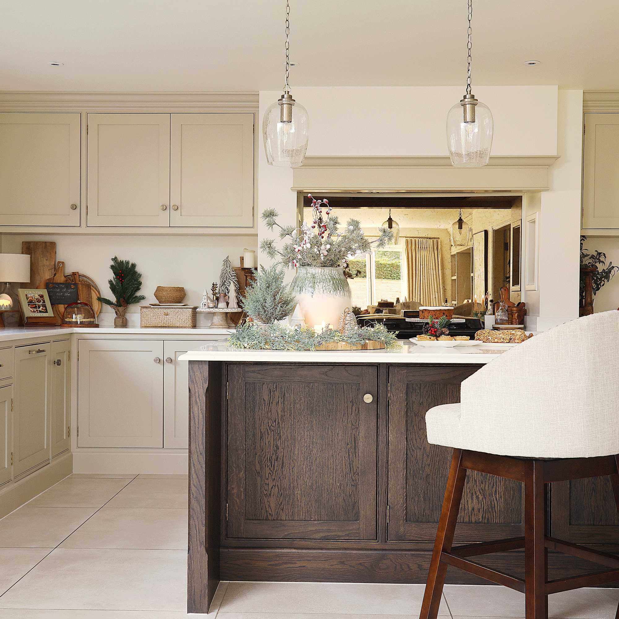 a neutral shaker kitchen with dark wood island and bar stools