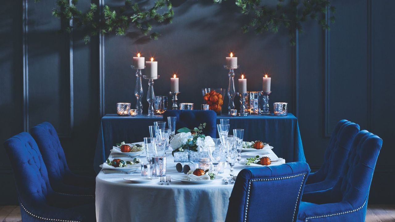 Dark Blue Christmas dining room with candles and velvet blue chairs