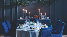 Dark Blue Christmas dining room with candles and velvet blue chairs