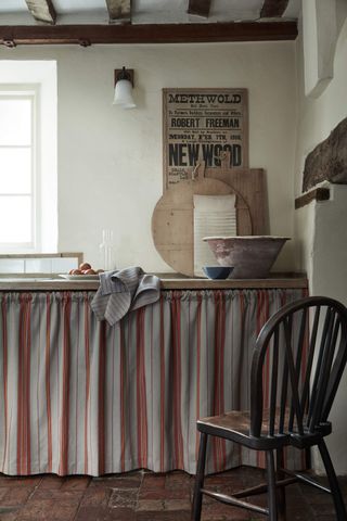 Kitchen cupboard with striped curtain