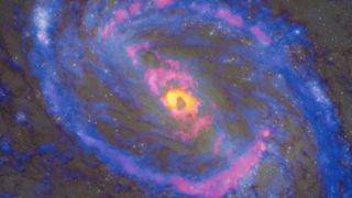 a spiral galaxy with an orange/yellow center and arms with pink and blue.