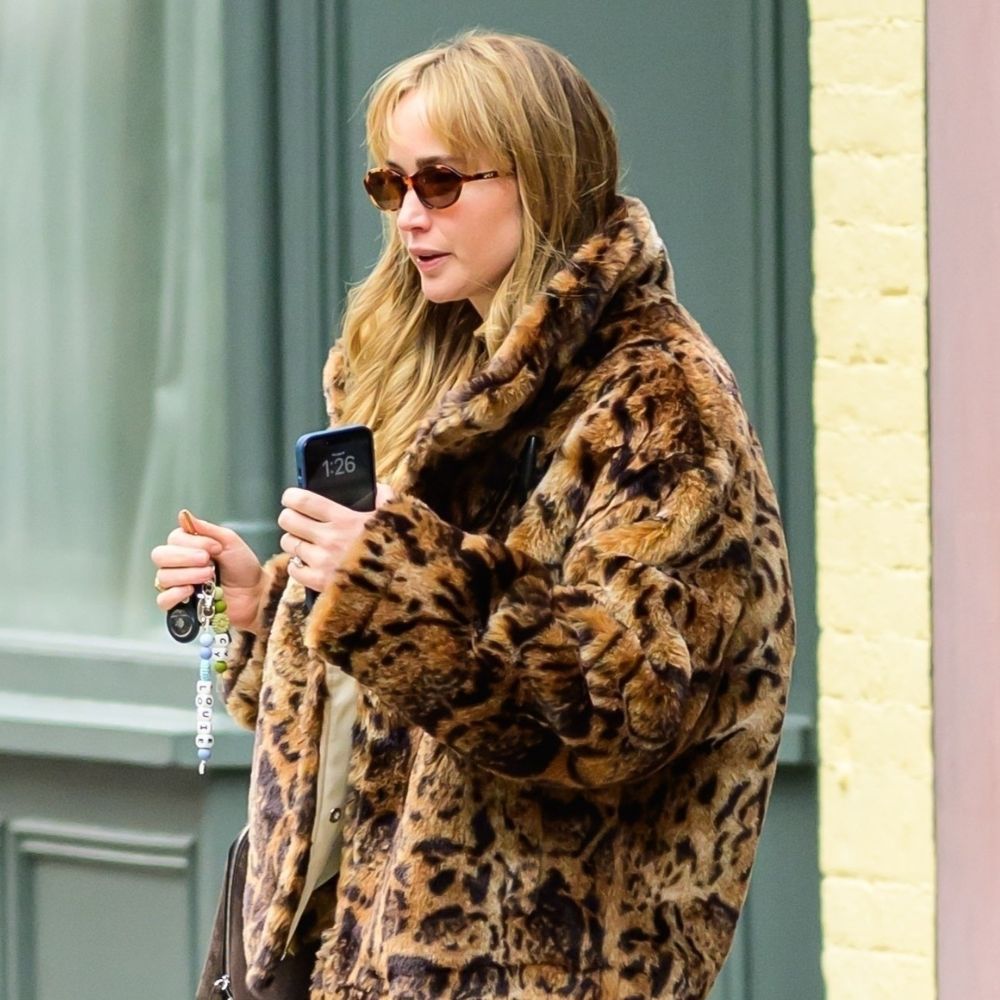 Jennifer Lawrence wears light beige track pants with a leopard print coat.