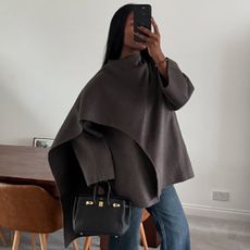 Marilyn wears a brown coat from cos with jeans and a black bag.