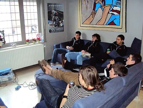 A group of riders sit around on the couch watching the only English thing on TV - the music video Chanel JIM. Summerhill says it's not only very addicting, but also a good way of bonding with fellow teammates while discussing how hot the singers are.