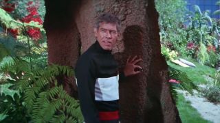 James Coburn leans against a tree in disguise in Our Man Flint.