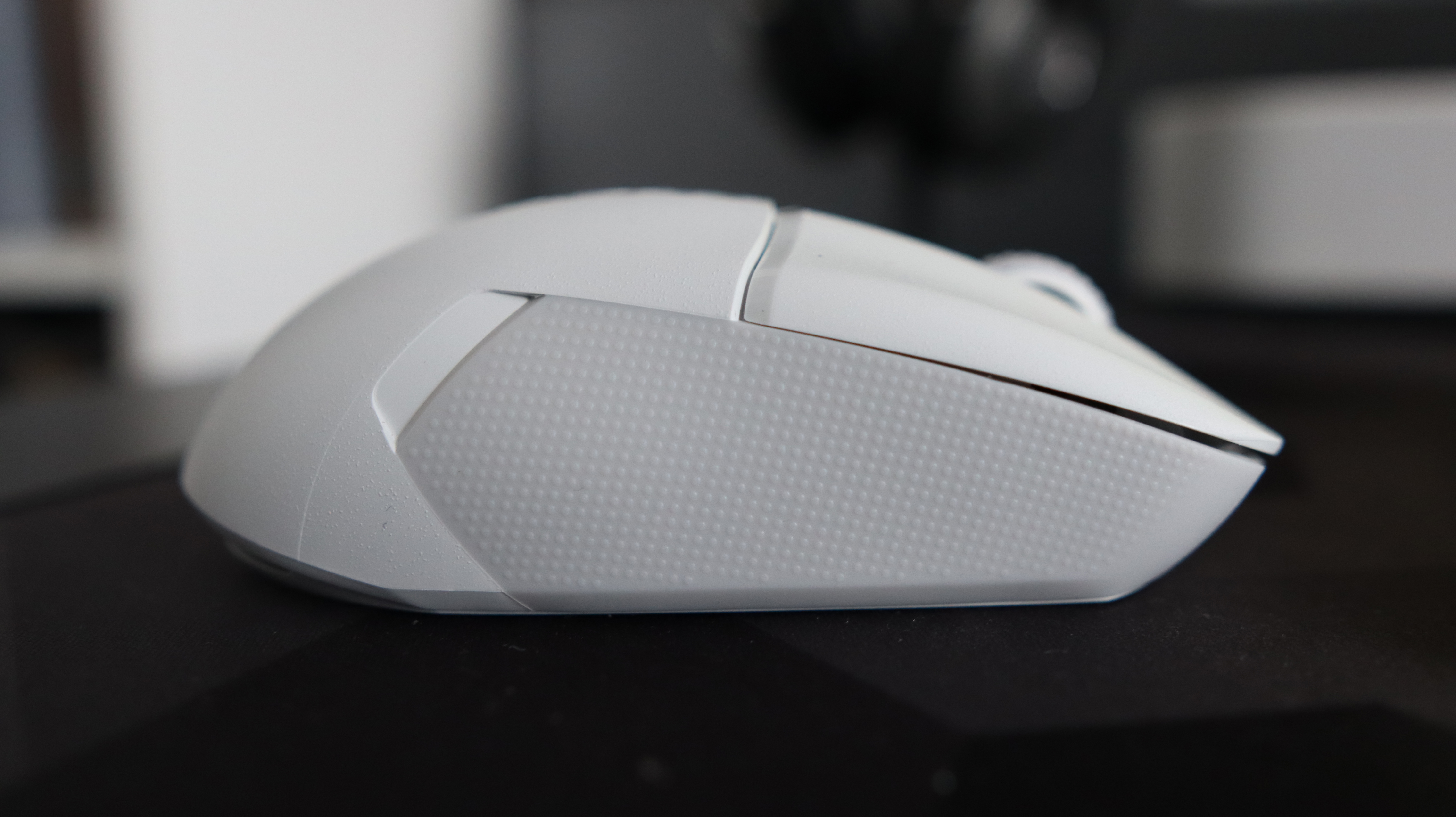 An NZXT Lift Elite Wireless gaming mouse in white set-up on a desk.