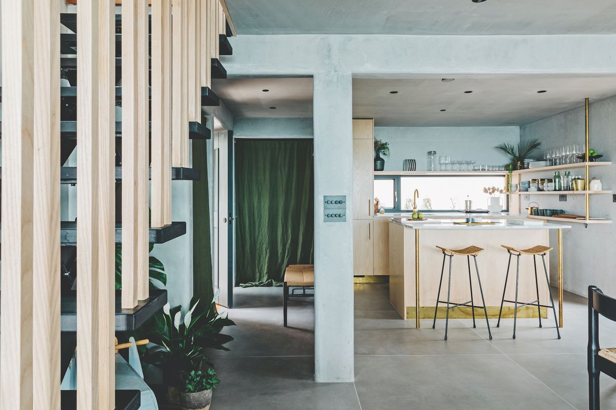 modern concrete kitchen with side view of wooden staircase