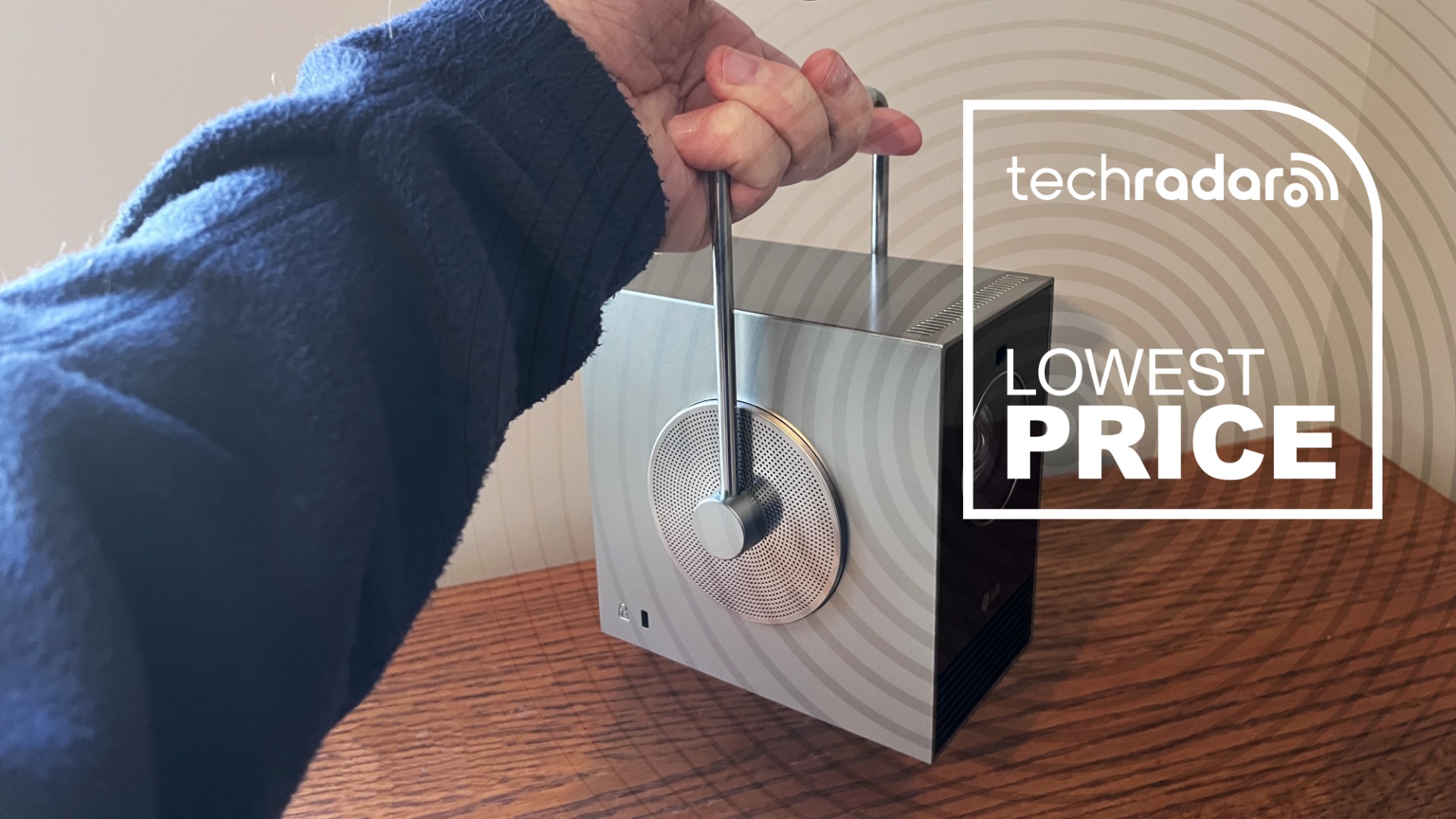 LG CineBeam Q projector held in hand with lowest price logo