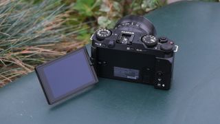 Fujifilm X-M5 camera with its screen folded out on a green surface