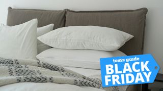 Bed with white pillows and striped duvet with Tom's Guide Black Friday badge on bottom right corner