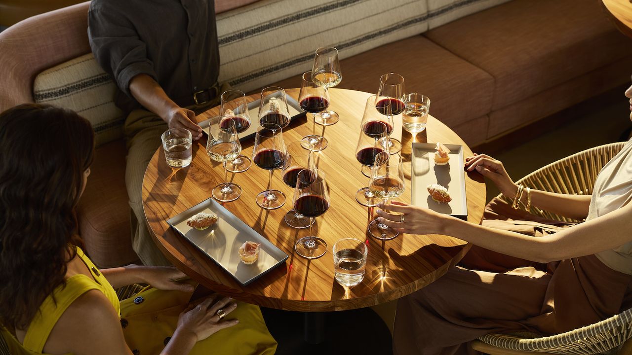Three visitors enjoying the Legends Tasting, with several wine samples and bites of food, in Robert Mondavi's new Vineyard Room.