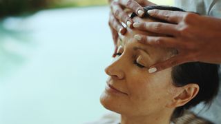 woman getting forehead massage, to signify scalp massage for hair growth