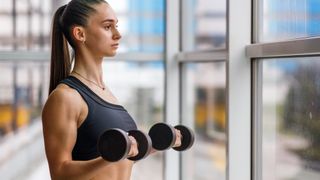 woman doing bicep curls with dumbbells 