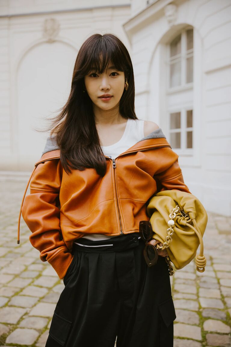 a woman wearing a pumpkin orange leather jacket