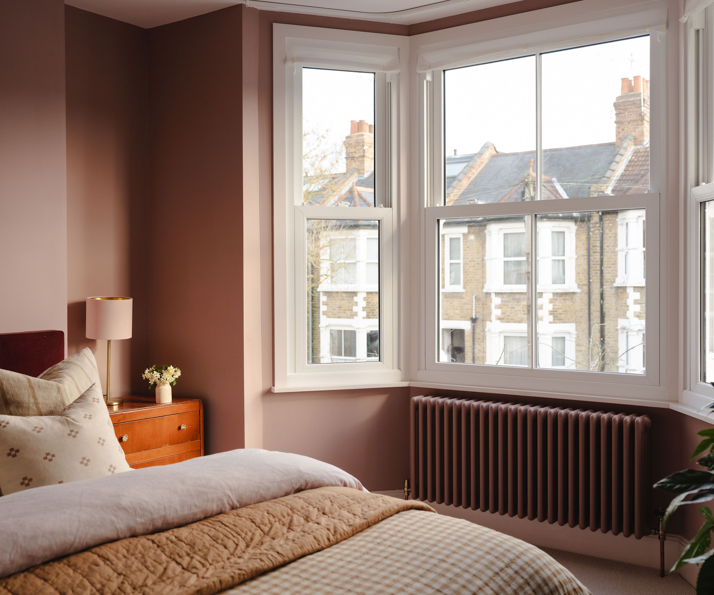 pink bedroom with bay window and column radiator