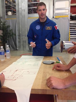 Canadian astronaut Jeremy Hansen briefs teammates while designing a rudimentary Mars lander at the Ontario Science Centre. Hansen was participating in an astronaut race in Toronto, Sept. 30, 2014.