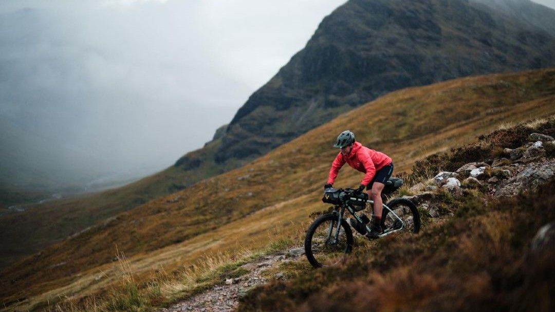 Jenny Tough descends a rocky trail on her loaded mountain bike