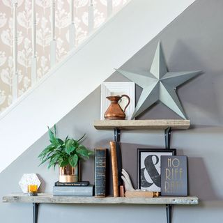 grey wall with wooden shelves and picture and books